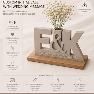 May include: A light gray 3D printed vase shaped like the letters E and K with an ampersand, featuring the text Together is a beautiful place to be, mounted on a rectangular wooden base and holding a bouquet of white baby's breath flowers.