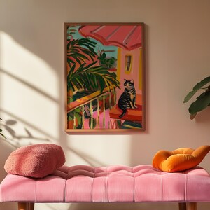 May include: A framed painting shows a cat on a porch with a pink roof and green plants. The artwork uses pink, green, and blue, creating a tropical scene. The painting hangs above a pink, tufted bench. The artwork is in a wooden frame.
