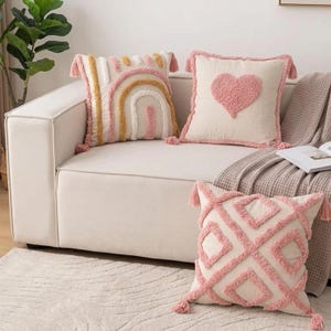 May include: A white ceramic mug with a black handle and the text "But First, Coffee" in a bold, black font. The mug is set against a blurred background, suggesting a cosy setting.