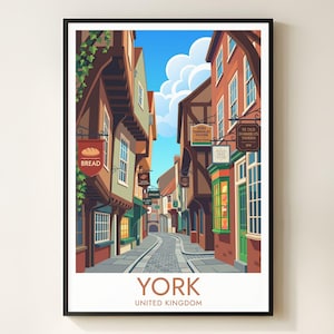 May include: A framed art print showing a vibrant illustration of a street in York, UK. The artwork showcases traditional buildings with shop signs, including a bakery and taverns, set against a blue sky. The word "YORK" is displayed at the bottom of the print.