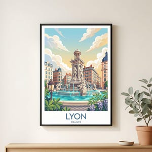 May include: A framed art print featuring a stylized illustration of Lyon, France. The artwork depicts a fountain in a city square, with buildings and a blue sky with clouds. The word "LYON" and "FRANCE" are printed at the bottom.