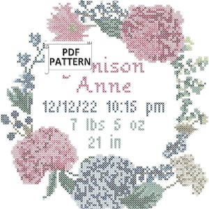 Puede incluir: Patrón de punto de cruz de una corona floral con el nombre "Amison Anne", la fecha de nacimiento "12/12/22 10:15 pm", el peso "7 lbs 5 oz" y la longitud "21 in".