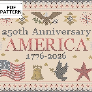 Op de afbeelding: Een kruissteekpatroon met een Amerikaans thema, met het woord "AMERICA" in rood, de jaren "1776-2026" en een Amerikaanse vlag. Het ontwerp bevat een adelaar, een bel, een duif en een ster, allemaal binnen een decoratieve rand.