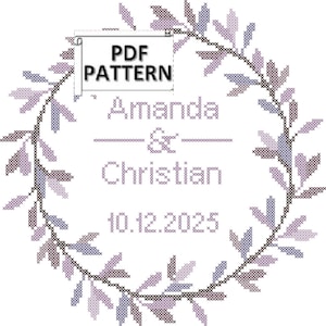 May include: A cross-stitch design featuring a circular wreath of leaves in shades of purple and gray. The text "Amanda & Christian 10.12.2025" is centered within the wreath. A small banner reads "PDF PATTERN".