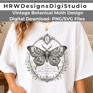 May include: A white t-shirt featuring a black and white graphic of a moth centered within an ornate oval frame. The moth wings contain botanical and mushroom illustrations. Below the moth, the text reads: I Fly Toward Chaos Like a Moth to a Flame.