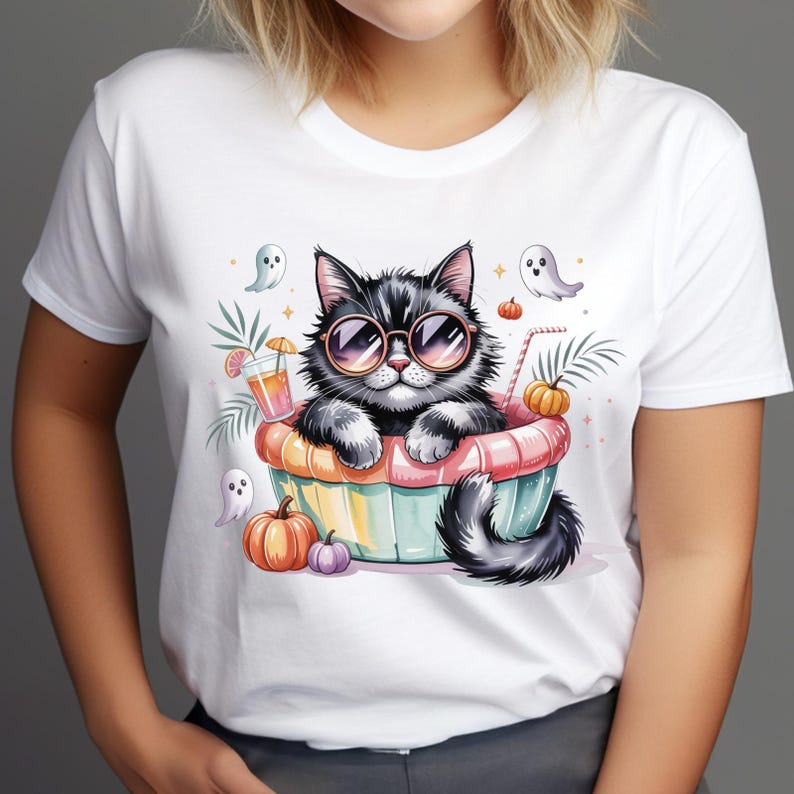 Op de afbeelding: Wit T-shirt met een cartoonkat met zonnebril, in een kleurrijke kom met pompoenen en geesten. Een drankje met een rietje en palmbladeren staan ook op de afbeelding. Halloween-thema kleding.