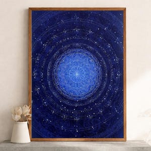 Può includere: Una stampa artistica incorniciata con un design mandala celeste nei toni del blu e del bianco. L'opera presenta cerchi concentrici con motivi intricati e dettagli stellati, creando un'estetica cosmica e spirituale. La stampa è racchiusa in una cornice di legno.
