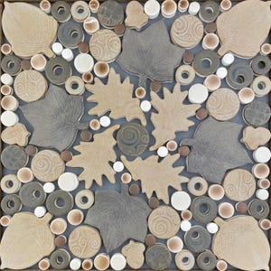 May include: A square tile mosaic featuring a nature-inspired design. The mosaic includes tan and gray oak leaves, acorns, and circular and donut-shaped elements in various shades of brown, gray, and white. The background is a muted gray.