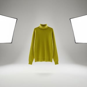 May include: A chartreuse ribbed turtleneck jumper. The long-sleeved garment is displayed against a white backdrop, lit by studio lights. The jumper is a solid colour and appears to be made of a soft knit material. The sweater is a vibrant shade of yellow-green.