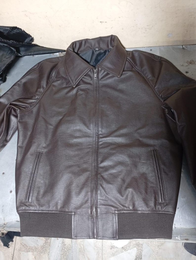 Puede incluir: Chaqueta de cuero marr&oacute;n con cremallera, cuello y dos bolsillos delanteros. La chaqueta tiene dobladillo y pu&ntilde;os acanalados. El cuero tiene un aspecto texturizado. La chaqueta es de estilo cl&aacute;sico.