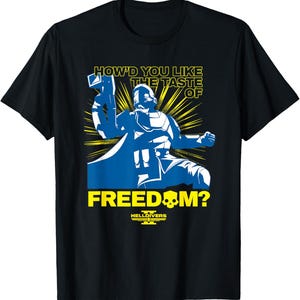 May include: Black t-shirt with a blue and white graphic of a futuristic soldier throwing a weapon. The text reads "HOW'D YOU LIKE THE TASTE OF FREEDOM?" with "HELLDIVERS" below. Yellow rays emanate from behind the soldier.