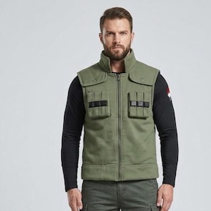 May include: An olive green tactical vest with a high collar, a full-length front zipper, and two chest pockets featuring black horizontal straps. The vest is worn over a long-sleeved black shirt, paired with olive green cargo pants and black boots.
