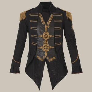 May include: Black military-style jacket with gold embroidery and fringe epaulets. The jacket features a high collar, decorative buttons, and a unique asymmetrical hemline. The sleeves have decorative gold trim and distressed detailing.