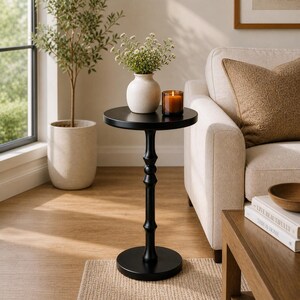 round pedestal side table near window in cozy small space living room
