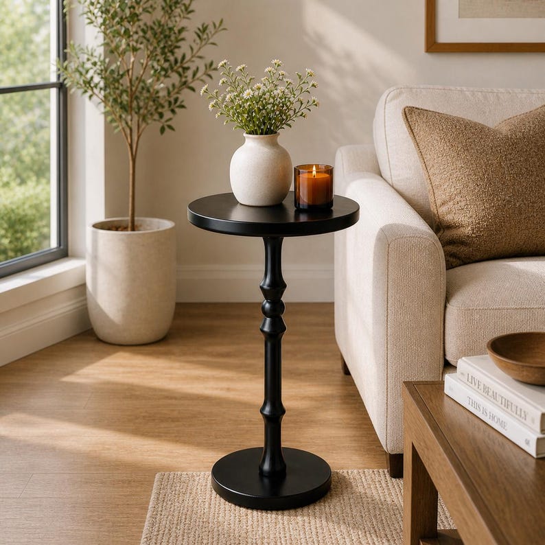 round pedestal side table near window in cozy small space living room