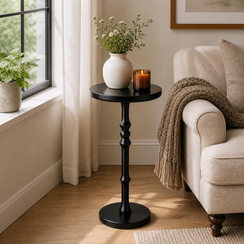 round pedestal side table near window in cozy small space living room