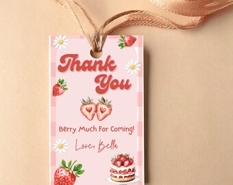 May include: A pink gift tag with a strawberry theme. The tag features the words "Thank You" in red script, along with strawberry illustrations, daisies, and the text "Berry Much For Coming! Love, Bella."