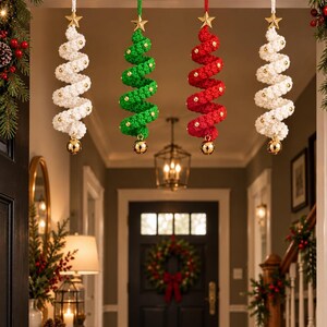 May include: Four spiral-shaped hanging ornaments in white, green, and red crochet yarn. Each ornament features a gold star at the top, small gold beads along the spiral, and a gold bell at the bottom, suspended by a white or colored string.