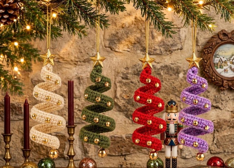 May include: Four spiral-shaped Christmas tree ornaments made of crocheted yarn in cream, olive green, red, and purple. Each ornament features small gold beads attached along the spiral and is topped with a gold star, hanging from a gold string.
