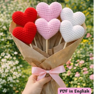 May include: A bouquet of crocheted hearts in red, pink, and white, wrapped in brown paper and tied with a pink ribbon. The hearts are attached to wooden sticks. The text "PDF in English" is visible in the bottom right corner.