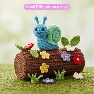 Könnte beinhalten: Eine gehäkelte Schnecke mit blauem Körper und grünem Gehäuse sitzt auf einem braunen gehäkelten Baumstamm, umgeben von bunten gehäkelten Blumen und grünem Gras. Der Text "Snail PDF pattern only" ist sichtbar. Ein bezauberndes Design.
