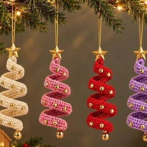 May include: Four spiral-shaped Christmas tree ornaments made of crocheted yarn in cream, pink, red, and purple. Each ornament features a gold star at the top, gold beads attached along the spiral, and a gold bead hanging at the bottom point.
