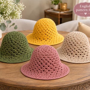 Puede incluir: Cuatro sombreros de pescador de ganchillo en verde oliva, amarillo brillante, rosa empolvado y beige. Cada sombrero presenta un patrón cuadrado calado repetitivo en la copa y el ala. Una etiqueta en la esquina superior derecha muestra el texto English pattern PDF.