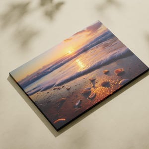 Puede incluir: Impresión rectangular en madera que representa una escena de playa al atardecer. La imagen muestra olas, conchas marinas y el reflejo del sol en la arena mojada. Los colores son cálidos, con tonos de naranja, amarillo y azul.