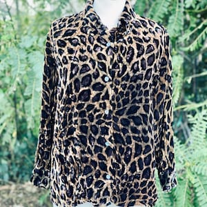 May include: A brown and black leopard print button-up shirt with long sleeves.