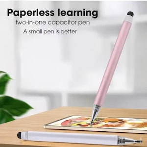 Peut inclure: Un stylet capacitif deux-en-un rose et argenté est présenté, avec le texte "Paperless learning" et "A small pen is better". Un stylet blanc et argenté est posé sur une surface en bois. Le stylet est conçu pour une tablette.