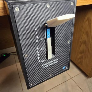 Peut inclure: Un levier de commande de volets pour simulateur de vol avec une texture en fibre de carbone noire et une poign&eacute;e blanche. Le panneau affiche le texte blanc WING FLAPS, des graduations de 0 &agrave; 30 degr&eacute;s et l'avertissement AVOID SLIPS WITH FLAPS EXTENDED.