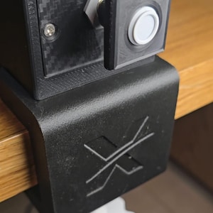 Peut inclure: Un bo&icirc;tier de commande noir &agrave; texture fibre de carbone, dot&eacute; d'un bouton blanc marqu&eacute; CARB HEAT et d'un logo X bleu sur le dessus. L'unit&eacute; est fix&eacute;e sur une base de serrage noire avec un logo X en relief et un bouton de serrage blanc en forme d'engrenage.
