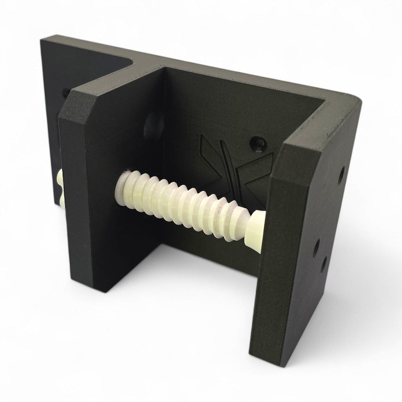 Peut inclure: Un support en forme de U noir mat dot&eacute; d'une tige filet&eacute;e blanche centrale &agrave; texture nervur&eacute;e. Le support pr&eacute;sente un cadre rigide et angulaire avec plusieurs trous de montage circulaires sur les panneaux lat&eacute;raux et un logo en creux.