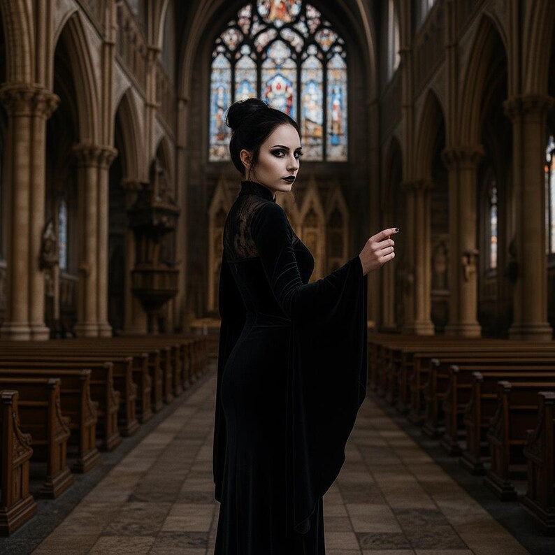 May include: A woman in a long black dress with flared sleeves stands in a church. The dress has a high collar and lace detailing on the shoulders. The church has stained glass windows and rows of wooden pews.