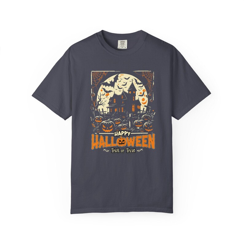 May include: A charcoal gray short-sleeve t-shirt featuring a graphic of a haunted house, bats, and jack-o'-lanterns in front of a full moon. The text reads Happy Halloween and Trick or Treat in orange and white lettering.