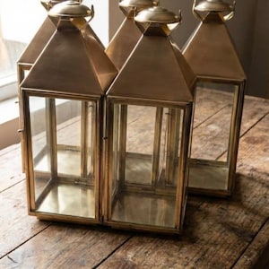 Handmade solid brass lantern candle holder with clear glass panels and polished brass finish