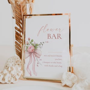 May include: A framed sign with gold trim, featuring the words "Flower Bar" in a script font. The sign includes a watercolor floral design with a pink bow and the text "mix and match blooms you love, a bouquet to take home, with thanks and a hug."