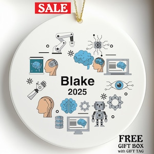 May include: White ceramic ornament with a gold string, featuring a design with a brain, robot, and computer graphics. The name "Blake" and the year "2025" are printed on the ornament. A red "SALE" tag is visible.