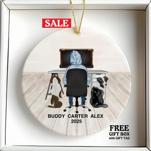 May include: Round ceramic ornament with a gaming theme. The design features a person in a hoodie at a desk with a computer, two dogs, and the text "BUDDY CARTER ALEX 2025". A red "SALE" banner is at the top.