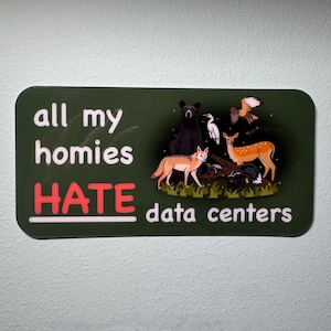 Könnte beinhalten: Ein rechteckiger Aufkleber mit abgerundeten Ecken. Der Aufkleber hat einen dunkelgrünen Hintergrund mit weißem Text, der "all my homies HATE data centers" in einer verspielten Schriftart lautet. Illustrationen von Wildtieren, darunter ein Bär, ein Hirsch und ein Fuchs, sind ebenfalls vorhanden.