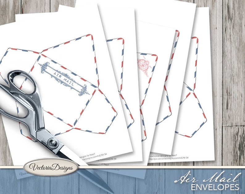 May include: A set of printable paper templates for air mail envelopes featuring a classic red and blue striped border design. One template displays the text AIR MAIL in a decorative frame. A pair of silver metal scissors is positioned over the sheets.
