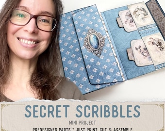 May include: A blue paper craft project titled Secret Scribbles Mini Project, featuring predesigned parts to print, cut, and assemble. The project includes a blue patterned folder with a central oval decorative element and internal pockets containing vintage-style illustrated cards labeled Journal and Let.