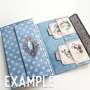 May include: A blue and white patterned paper folder with a decorative jeweled embellishment. The folder has two pockets labeled "Journal" and "Letter".