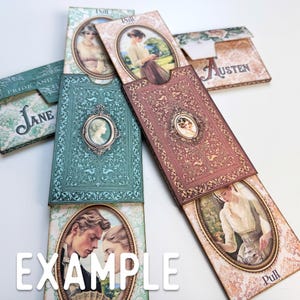 May include: A collection of rectangular paper pull-out cards featuring vintage-style portraits in oval frames. The designs include intricate floral patterns in teal, burgundy, and cream, with text reading Jane, Austen, and Pull printed on the surfaces.