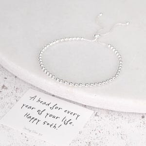 May include: A silver beaded bracelet with an adjustable fastening. A small card reads "A bead for every year of your life. Happy 50th!" The card also says "Sterling Silver 925".