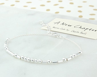 Pulseira em prata de lei com código Morse "A New Chapter", em apoio ao combate ao câncer.