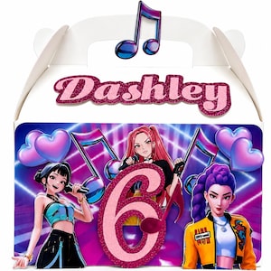 Puede incluir: Una caja de regalo de cartón blanco con el nombre Dashley en texto de purpurina rosa. El frente muestra tres personajes animados, un gran número 6 de purpurina rosa, notas musicales y corazones morados sobre un fondo vibrante morado y azul.
