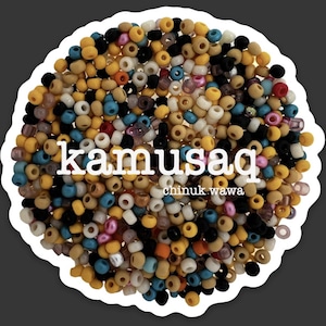 May include: A sticker featuring a collection of small, colorful beads in various shades of yellow, black, white, blue, and pink. The word "kamusaq" is printed in white, along with "chinuk wawa". The beads are arranged in a circular pattern.