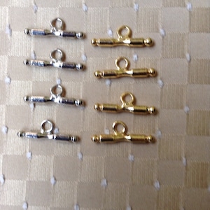 May include: Eight toggle clasps, four silver and four gold, for jewelry making. The clasps are about 1 inch long and have a simple design.