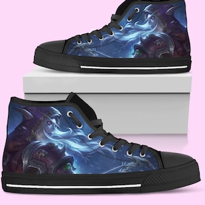 Op de afbeelding: Paar hoge canvas sneakers met een fantasy art design in blauw, paars en wit. De sneakers hebben zwarte veters, een zwarte neus en een zwarte zool met een witte streep. Het kunstwerk toont een vrouw met lang wit haar en een figuur met een kap.